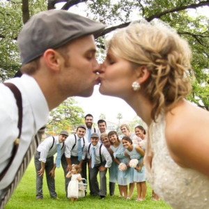 bride and groom kissing with people watching in background