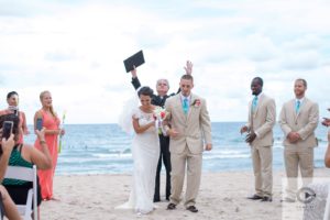 priest at beach wedding ceremony