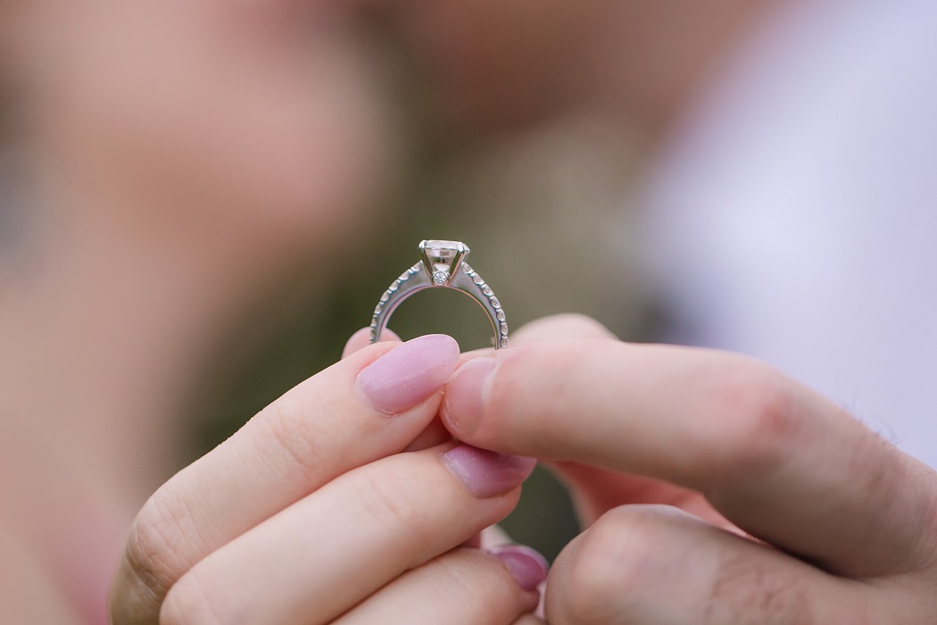 Holding engagement ring kissing