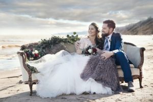 Bride and Groom on couch on the beach