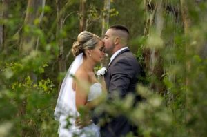 Groom kissing bride on forehead