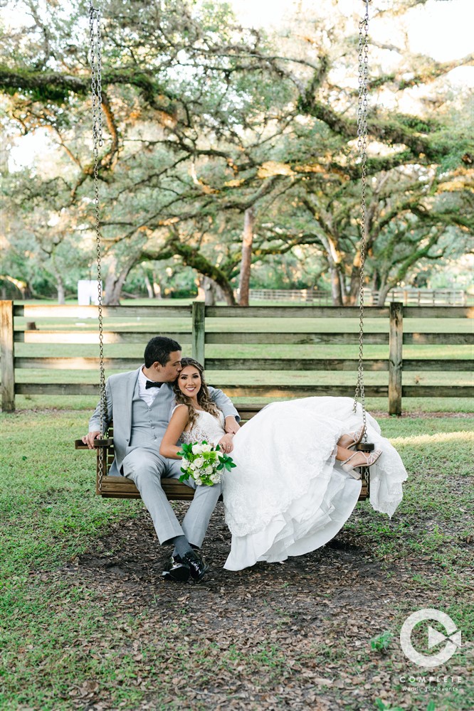 bride and groom sit on bench
