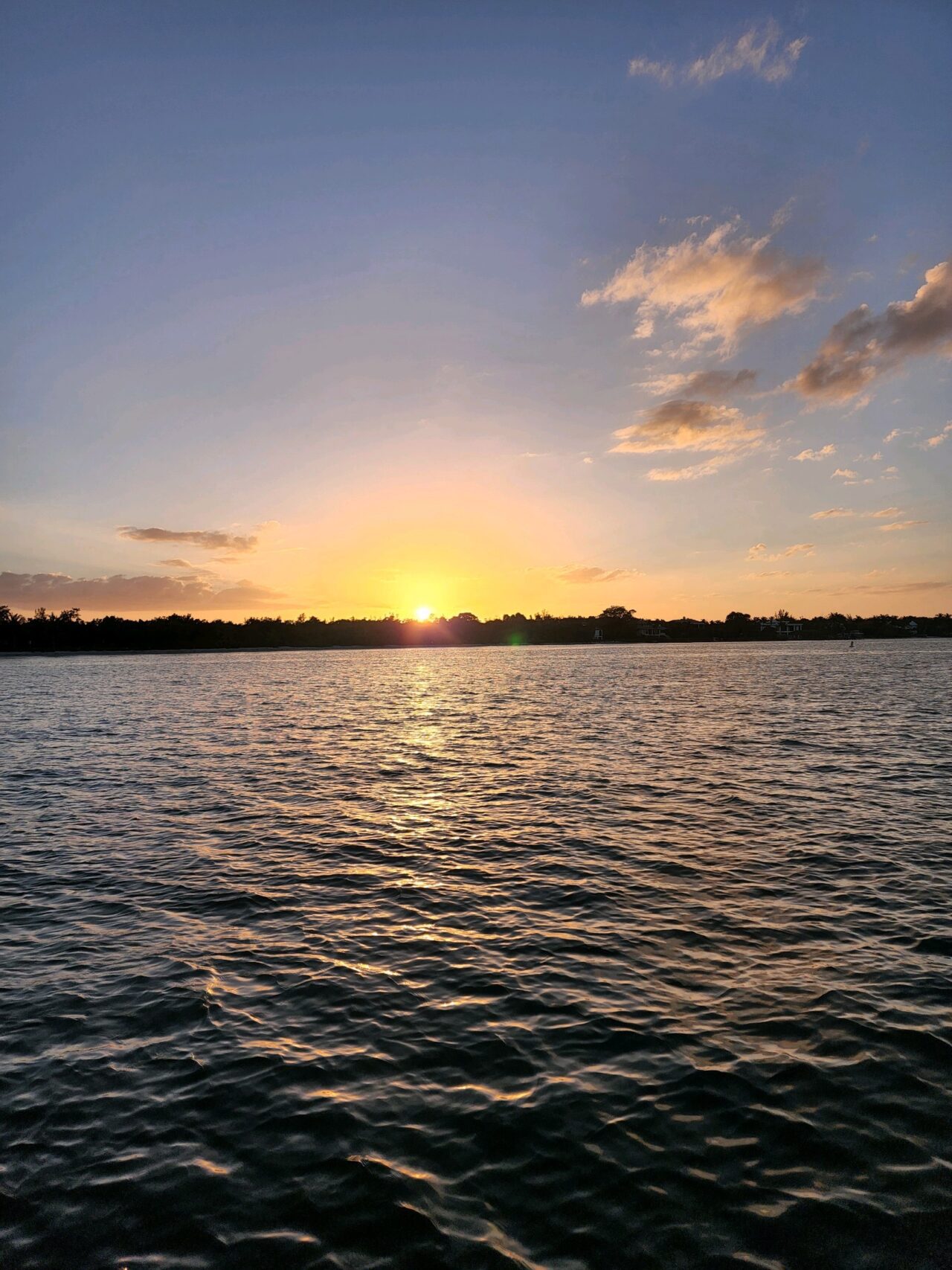 a serene yellow sunset from the deck of Sunset Ski and Watersports charter