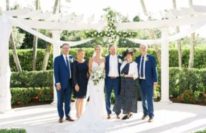 Bride and Groom with their parents pose by the altar