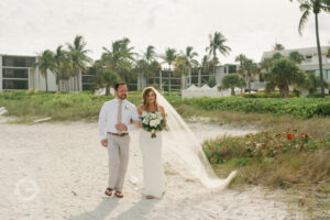 Man and Woman in gown and veil Walking arm in arm to get married