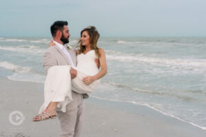 Groom Picking up New Bride on the beach as if to carry across Threshold