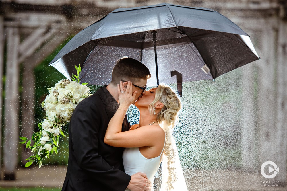 BARN AT BAY HORSE INN WEDDING VENUE GREENWOOD INDIANAPOLIS INDIANA BRIDE GROOM KISSING IN RAIN