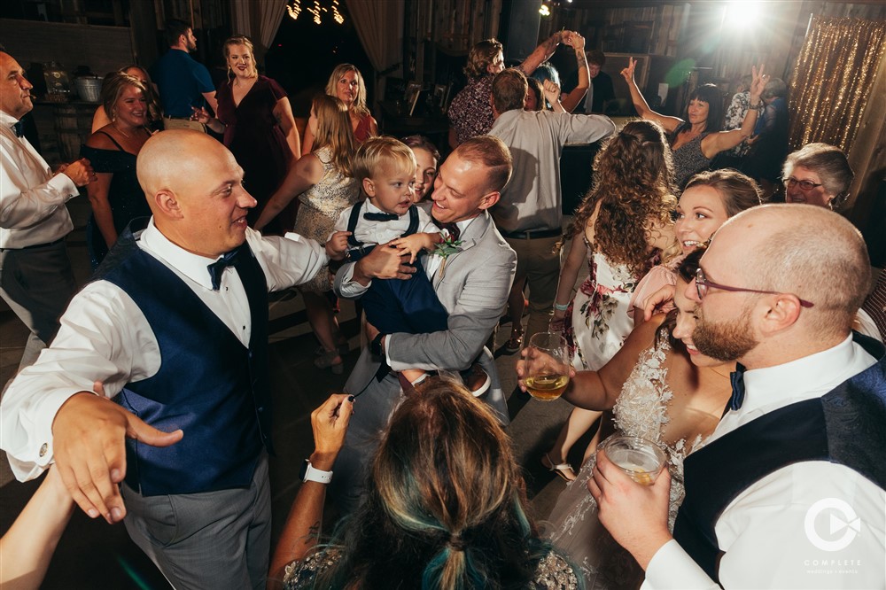 WEDDING MUSIC MISTAKES TO AVOID GROOM AND GUESTS SHARE A GREAT TIME ON DANCE FLOOR INDIANAPOLIS WEDDING
