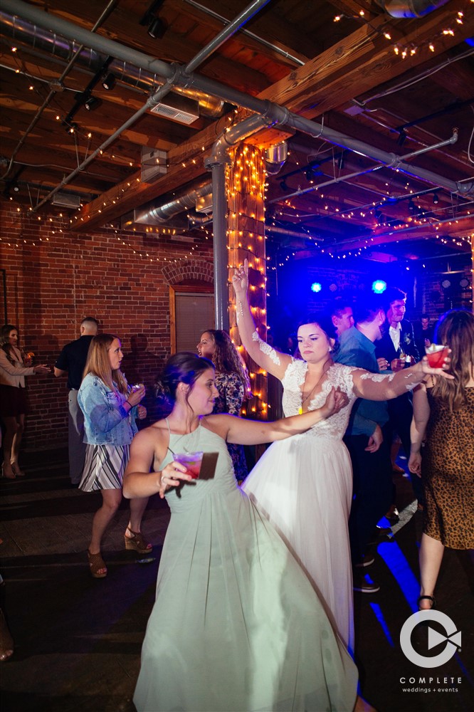 WEDDING MUSIC MISTAKES TO AVOID BRIDE ENJOYS SONG WITH BRIDESMAID IN INDIANAPOLIS