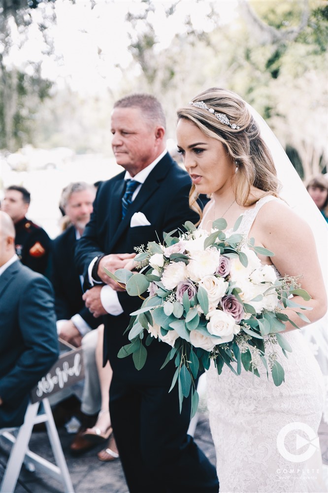 Bride walking down isle at Laytn's Land-n for Fall wedding in Yustes with her father