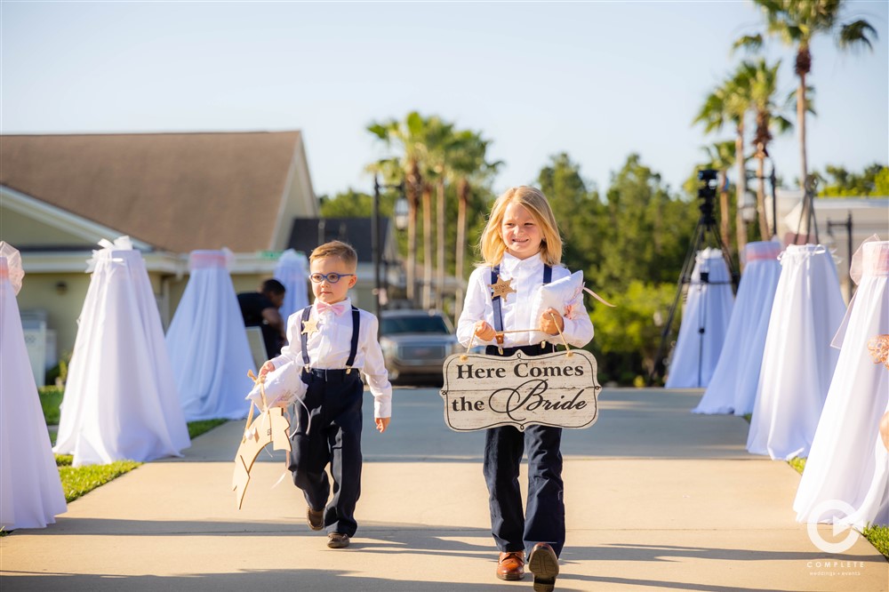 Bride gets ready to walk down the isle while ringbearer and flower girl walks down the isle on Fleming Island