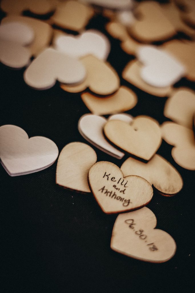 Close up of wooden heart cut outs for guest book at a June wedding in Kansas City