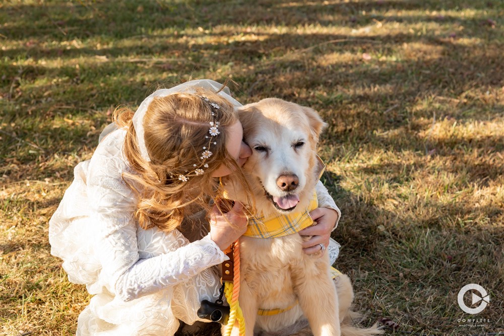 bride hugging her dog in yellow bandana