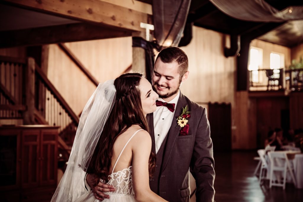 Image, with sepia effect, of bride and groom smiling at each other.