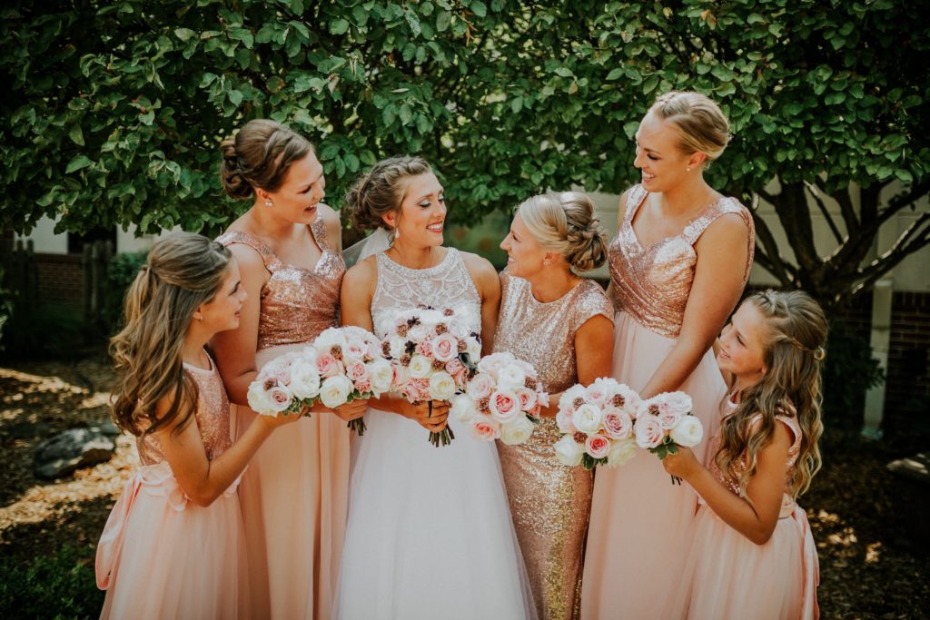 Bride and bridesmaids talking, smiling and laughing.