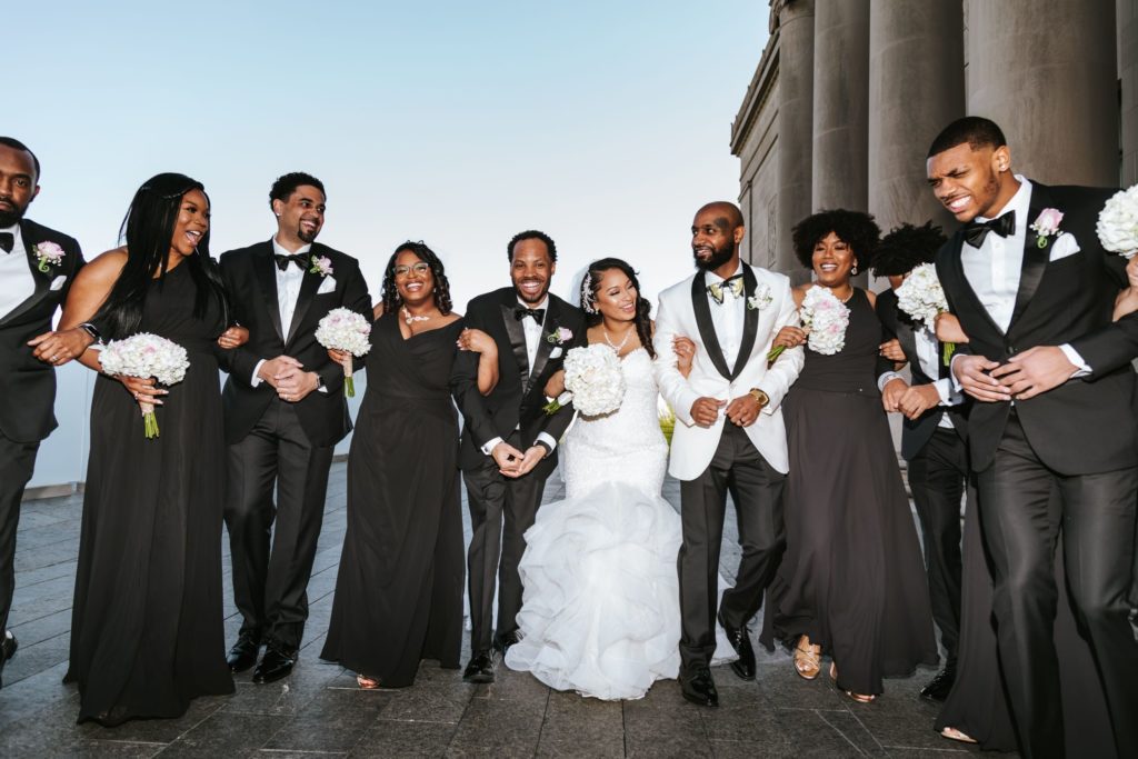Wedding party linked arm and arm for group photo