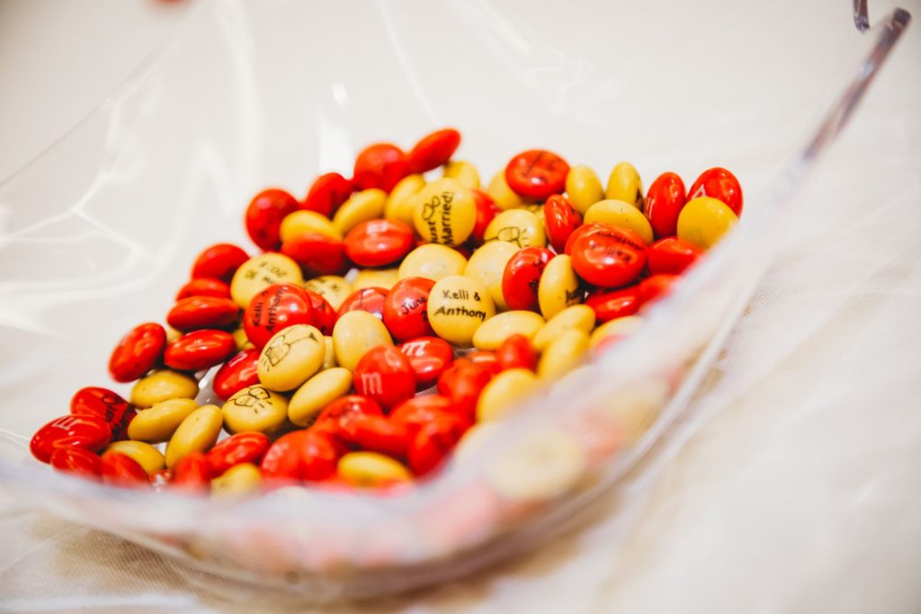 Personalized red and yellow m&ms have the bride and grooms names and date on them