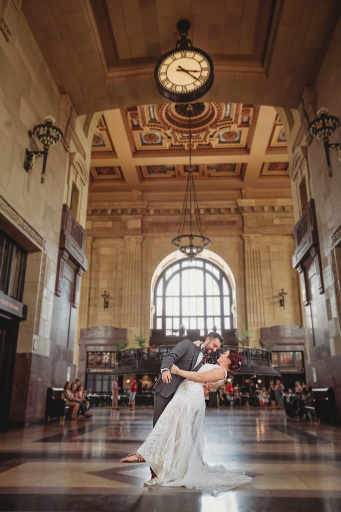Bride and groom sharing a kiss under the clock at Union Station in Kansas City