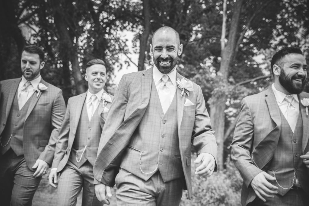 Close up of groom walking with his groomsmen