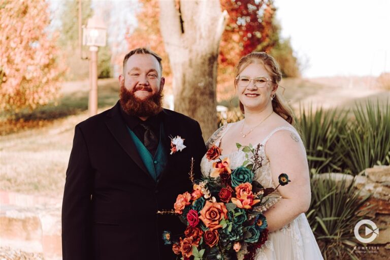 Bride and groom standing together with a colorful fall bouquet at Backwoods Venue 222 wedding venue photographed by Kansas City wedding photographer Serenity with Complete Weddings and Events