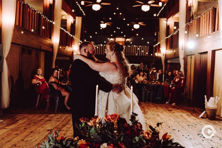 Bride and groom sharing their first dance in the barn reception hall at Backwoods Venue 222 wedding venue photographed by Kansas City wedding photographer Serenity