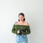 Kansas City wedding photographer Sophie holding her camera in a bright portrait