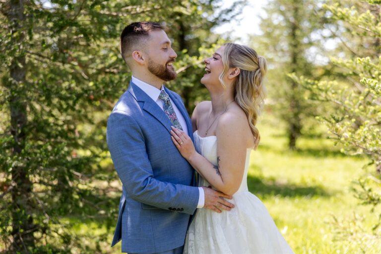 Bride and groom laughing together in an intimate portrait among the evergreen trees at Cedar Valley Forest in De Soto, Kansas