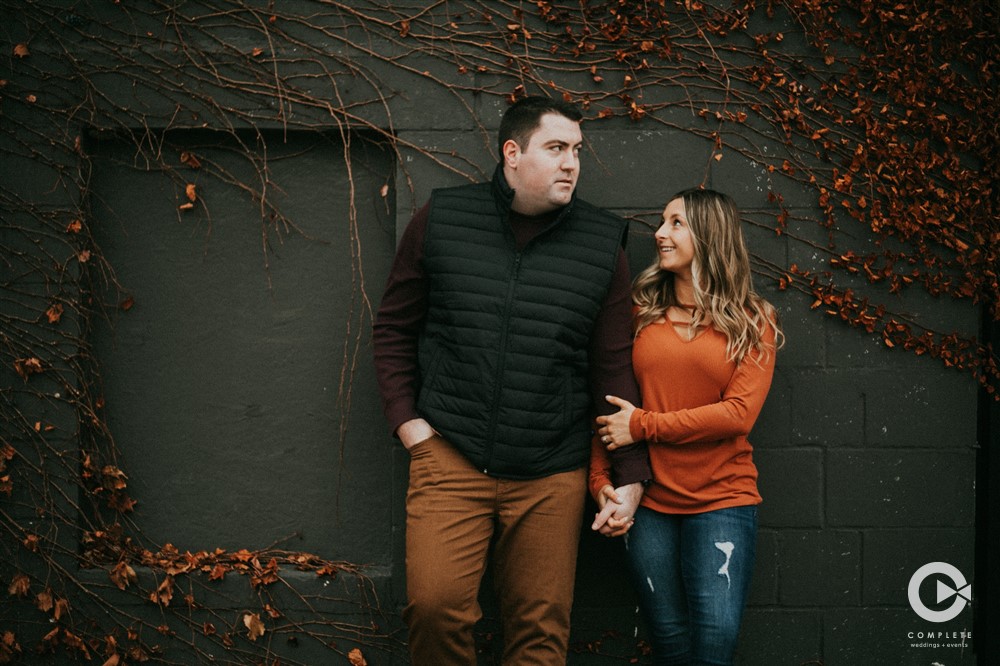Engagement photos of bride and groom together wearing Autumn colors