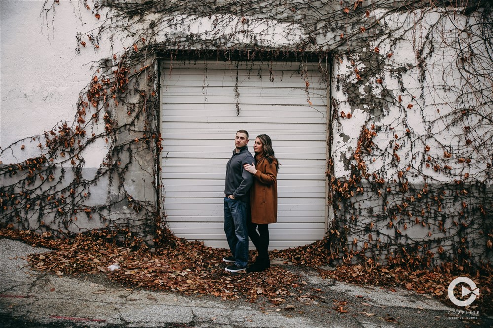 Engaged couple in front of a garage