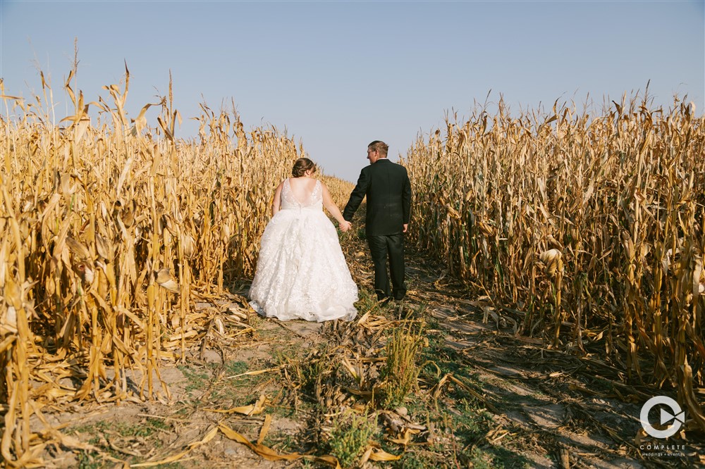 The couple in a wedding taking a photo in a corn field Nebraska High Plains