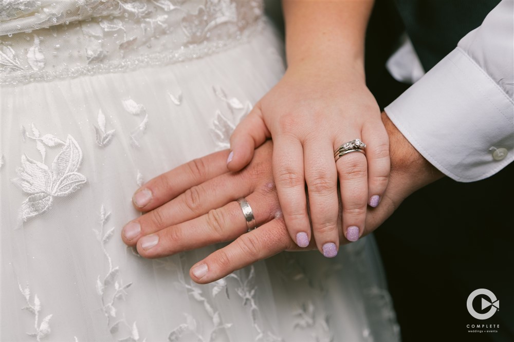 Wedding rings with hands in Nebraska High Plains during Fall wedding ceremony