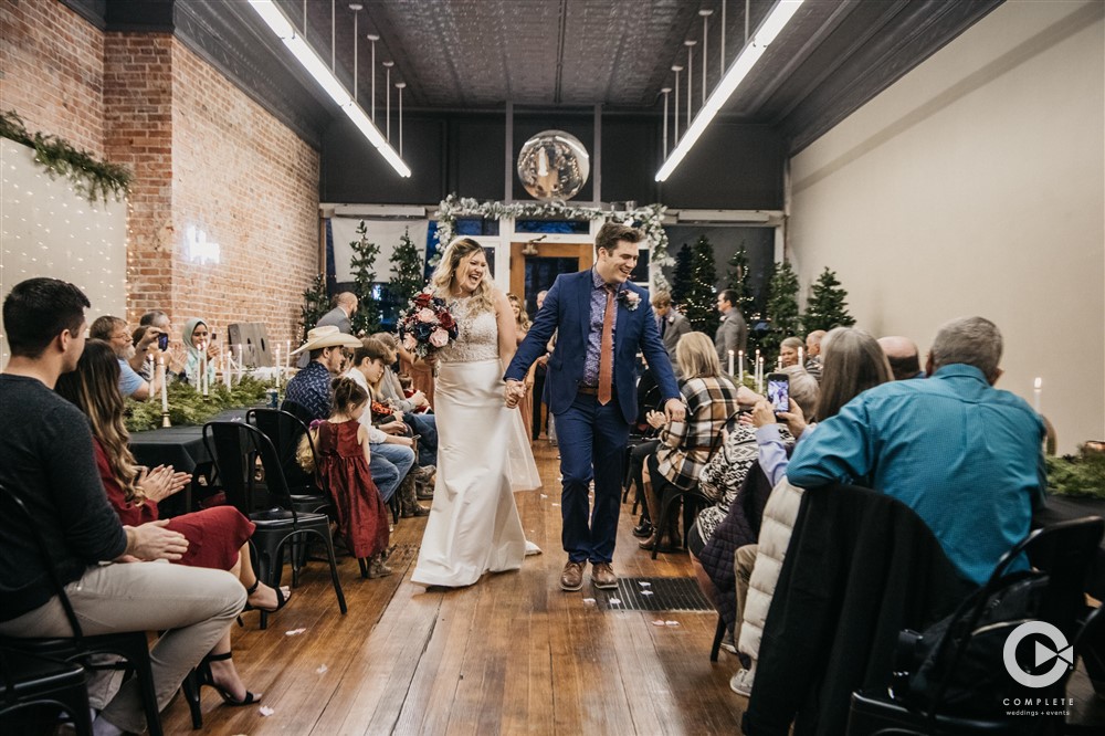 bride and groom walk down aisle