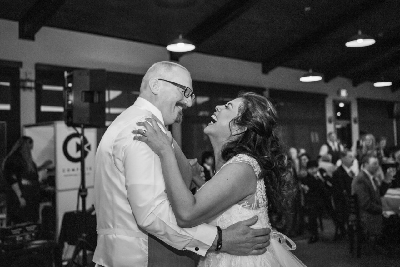 black and white image of bride and groom laughing