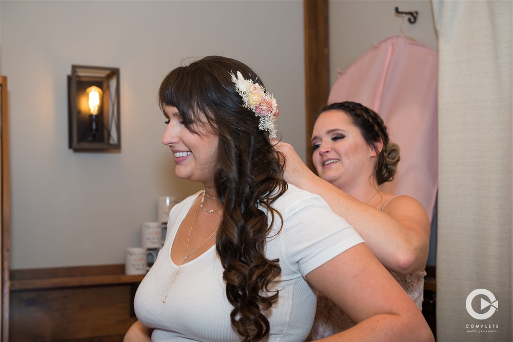 Bridesmaid putting on necklace