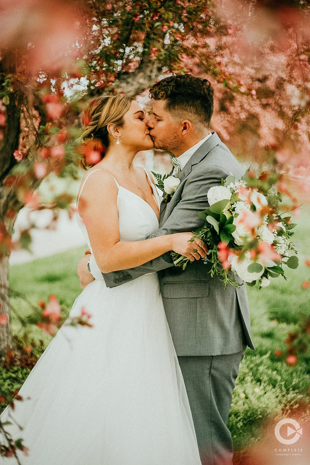 Bride and Groom under pink leaves.