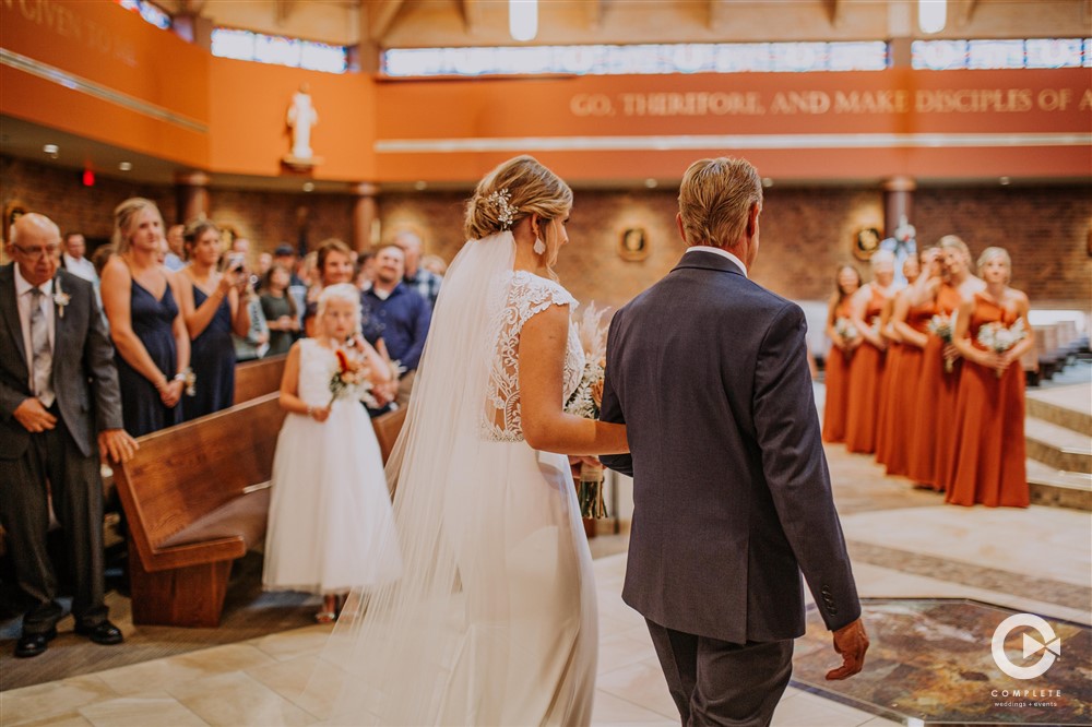bride and father walk in aisle