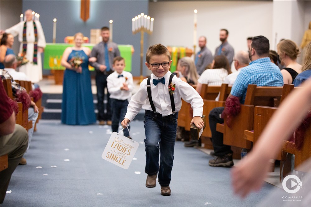 boy runs with wedding sign