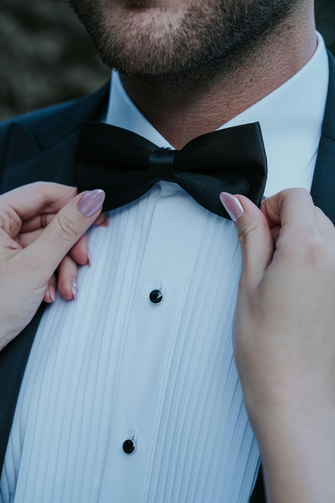 Adjusting a man's bow tie - demystifying wedding dress codes