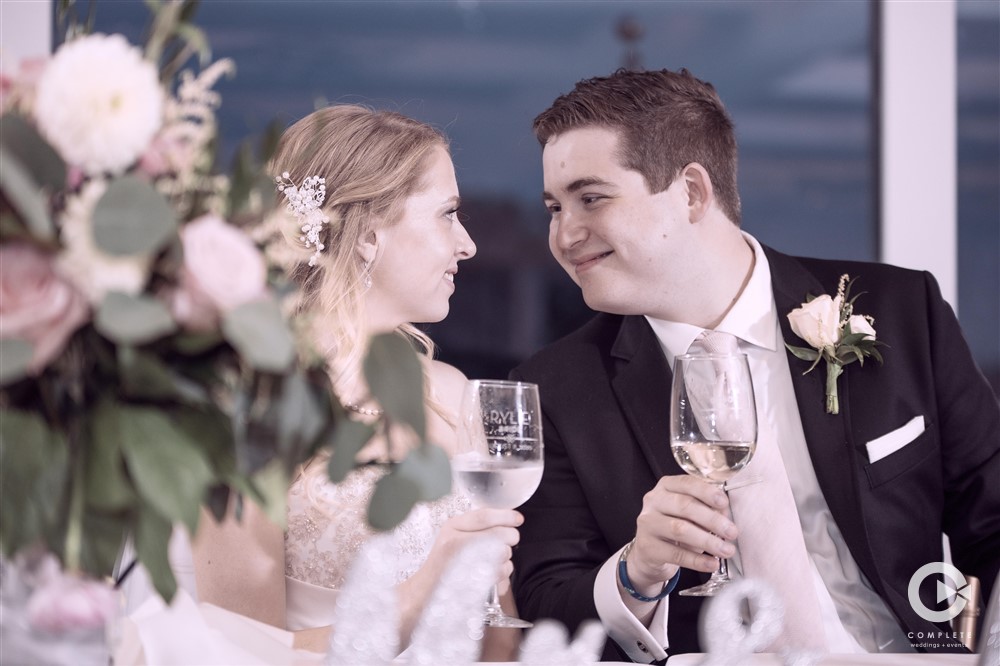 Wedding couple drinking wine during dinner looking at each other awesome moment captured