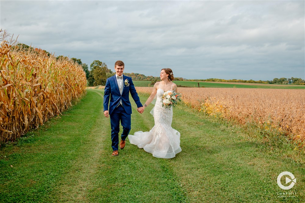 Wedding Day Advice For Brides Bride and groom walking in field near Milwaukee Wisconsin after wedding ceremony taking photos