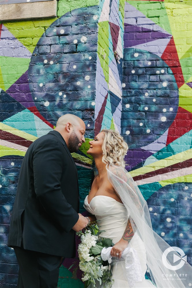 Milwaukee Wisconsin wedding photo of bride and groom kissing in front of mural