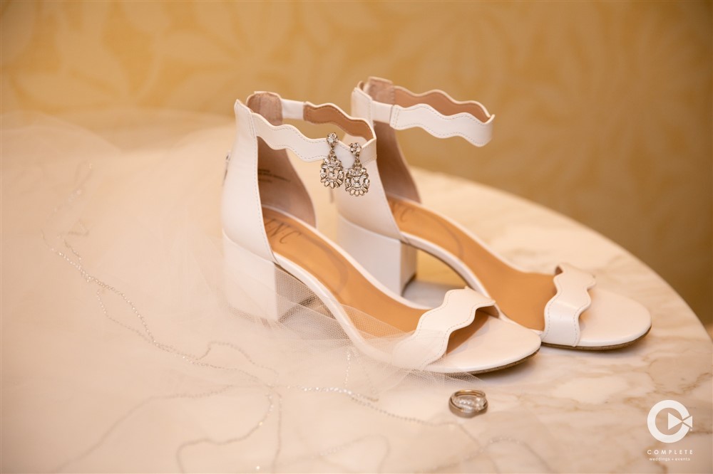 Stylish heels for wedding shoes and wedding rings and earrings hanging off shoes