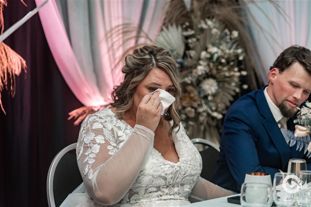 Bride in tears during speeches by Complete Weddings