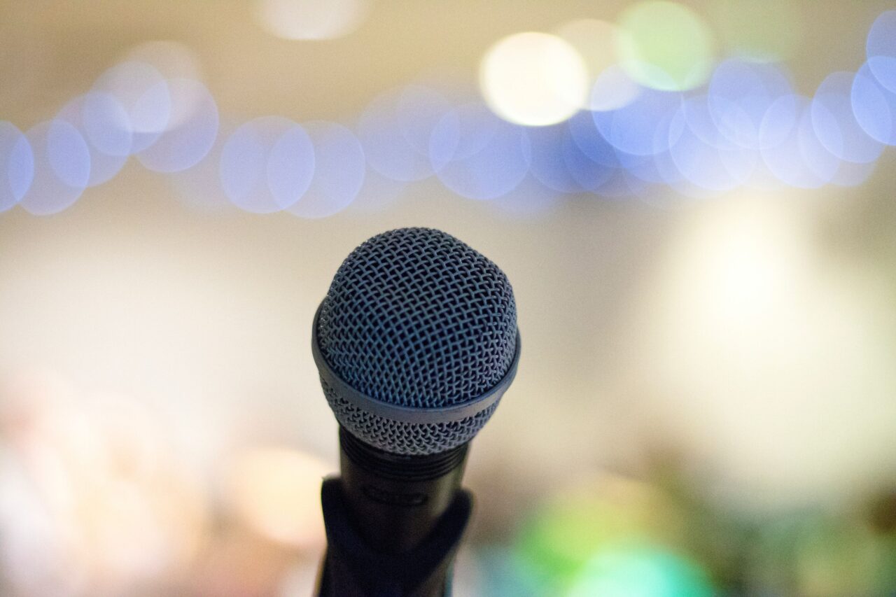 Close-up of a microphone at a wedding reception, representing the importance of professional DJs for announcements, speeches, and seamless event flow.