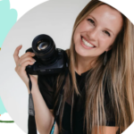 A photo of Nashville wedding photographer Anna Mahoney holding her camera and smiling at the camera in a professional headshot.
