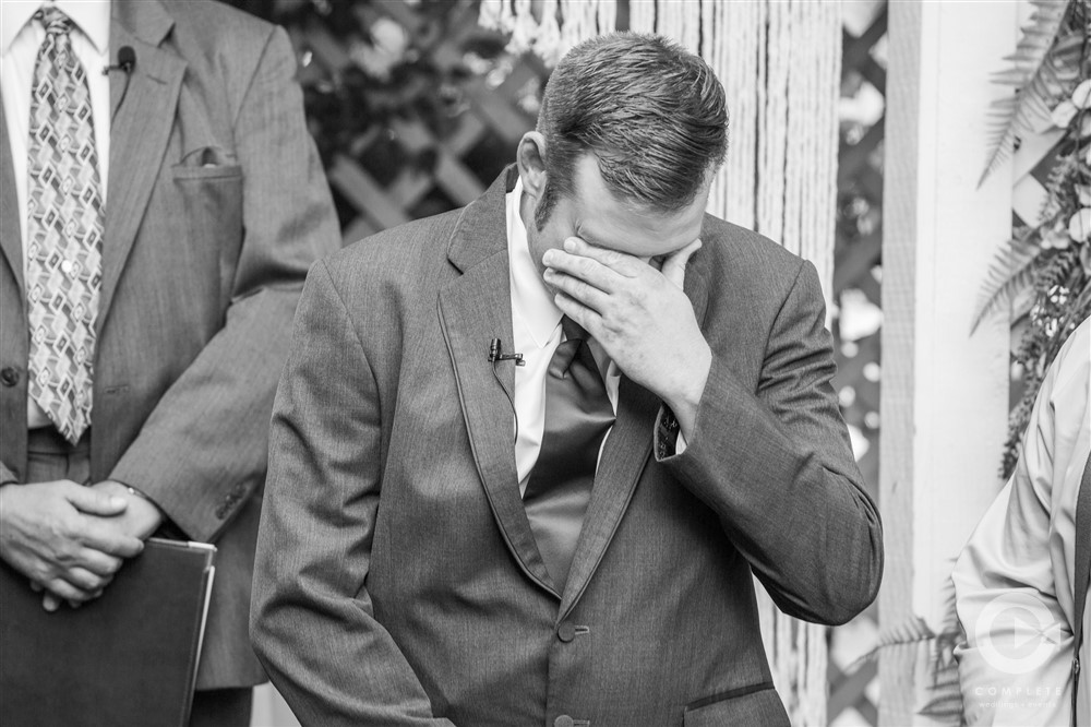 groom cries at altar in black and white