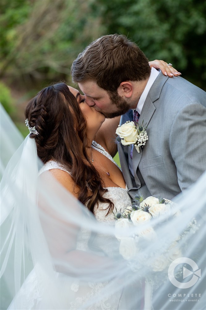 bride and groom kiss behind veil after Kindred North Wedding