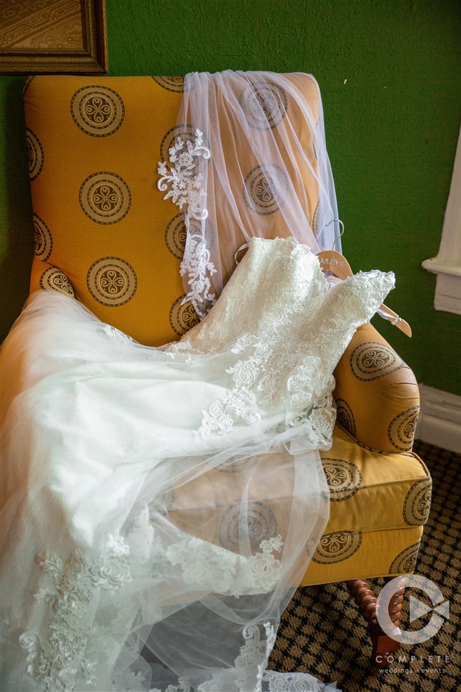 bridal dress laying on lovely yellow chair