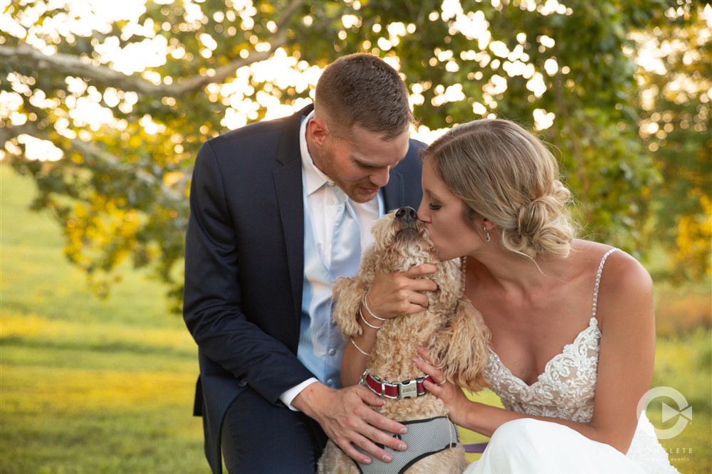 bride and groom giving love to their dog