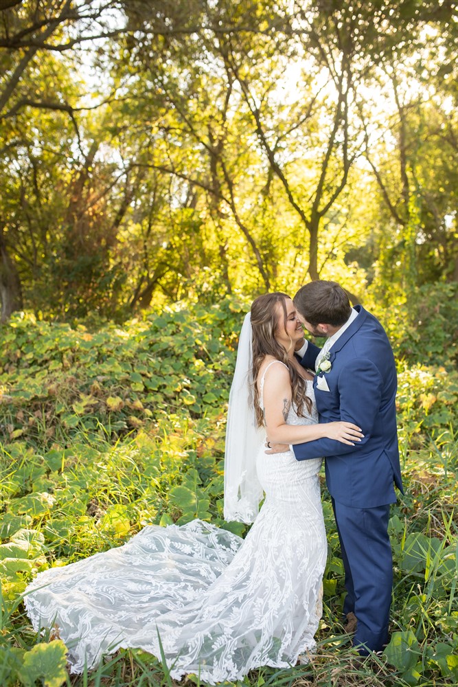 Bride and groom kissing photo at the Farmhouse venue outside of Omaha with wedding photographer Cassie Burley